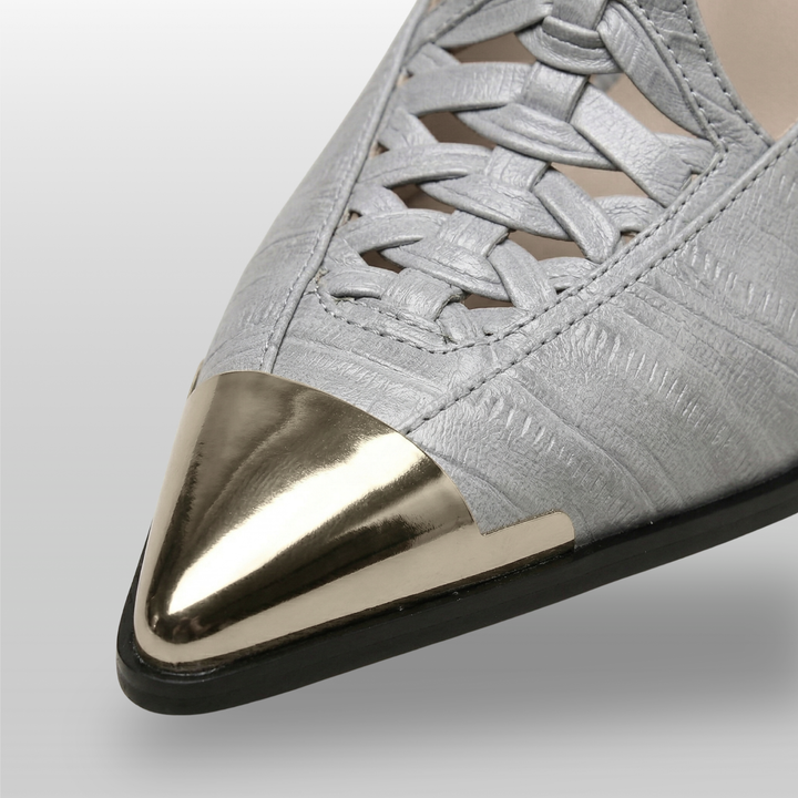 Gray shoe with a silver pointed toe on a light gray background