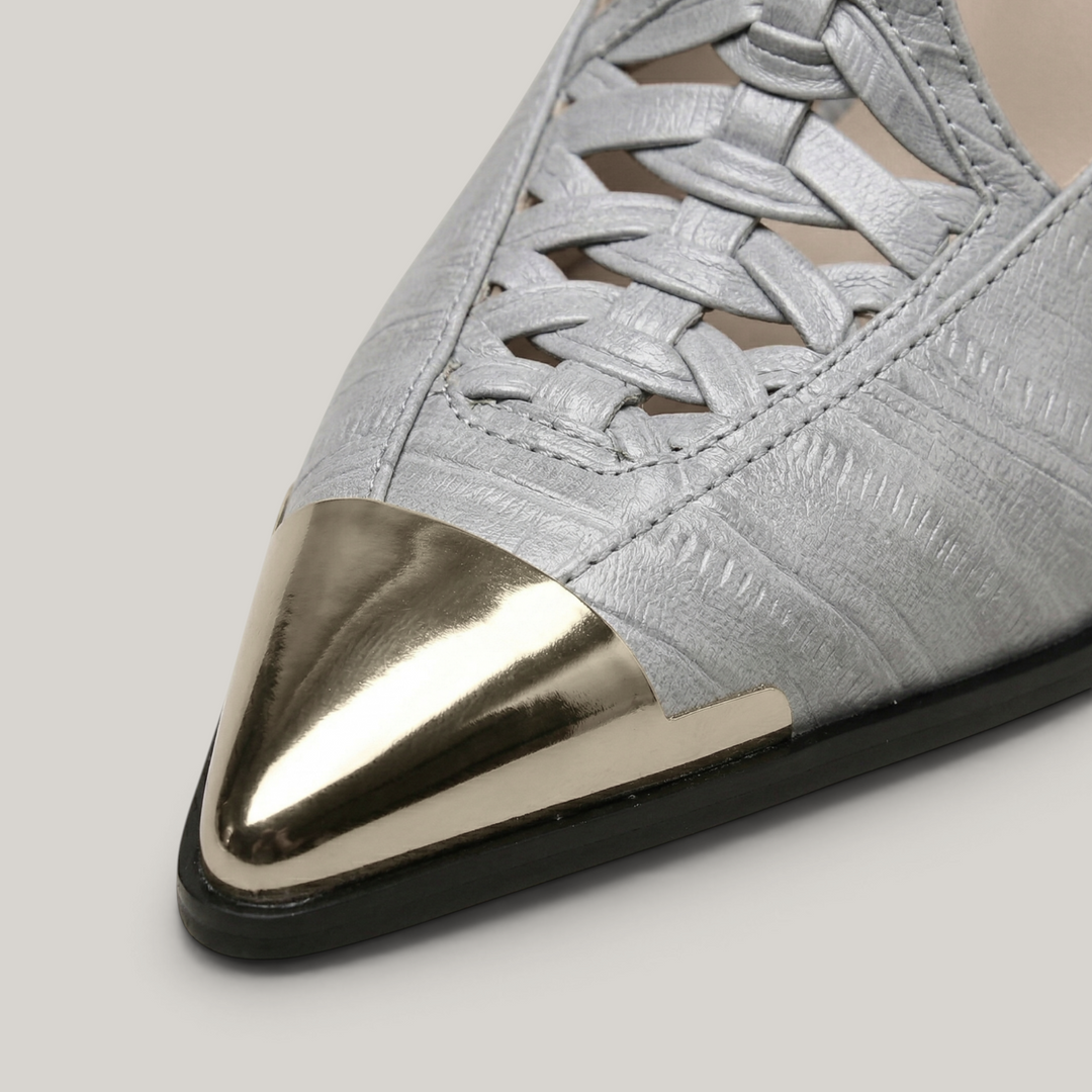 Gray shoe with a silver pointed toe on a light gray background