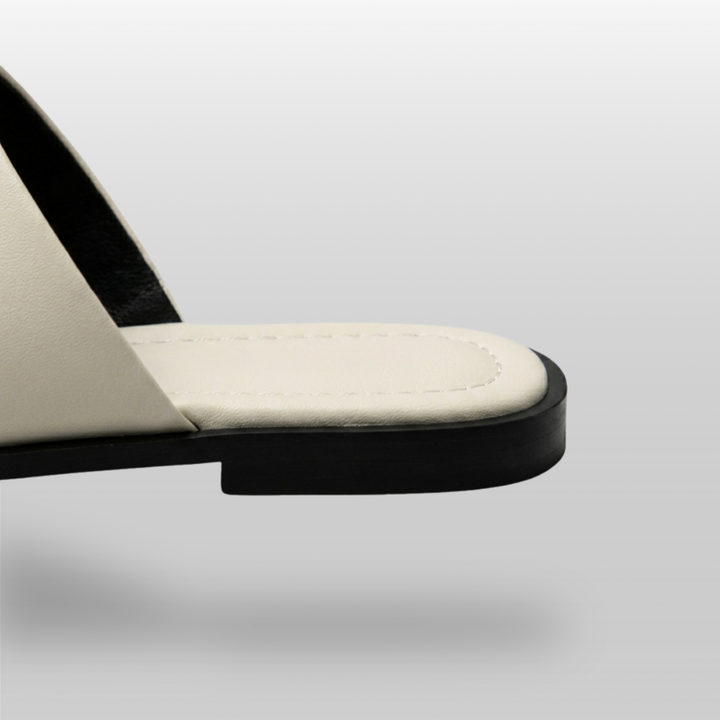 Cleo Sandal in Ivoire Argenté. Ivory footbed with perimeter pick-stitching and clean black TPR flat sole.