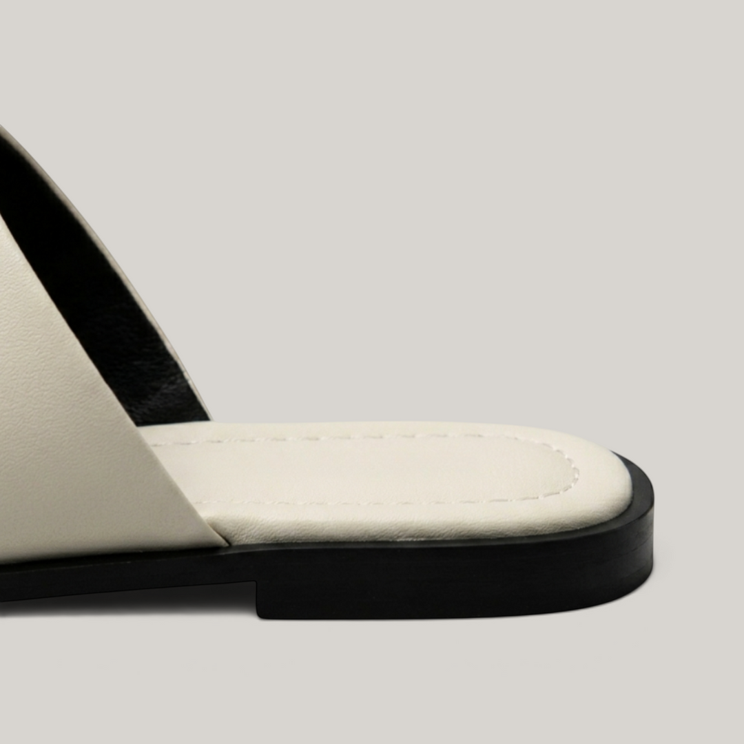 Cleo Sandal in Ivoire Argenté. Ivory footbed with perimeter pick-stitching and clean black TPR flat sole.