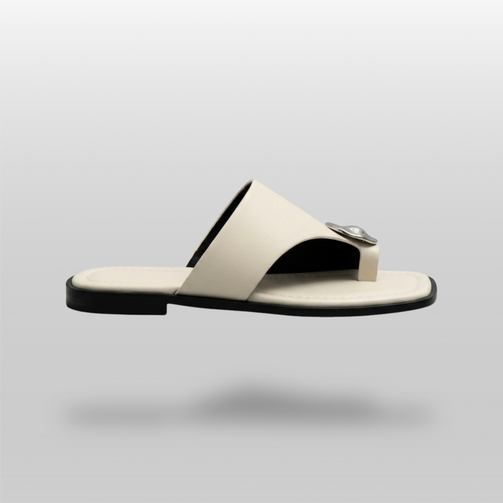 Cleo Sandal in Ivoire Argenté. Lateral profile showing the single ivory band, molten silver medallion and flat sole.