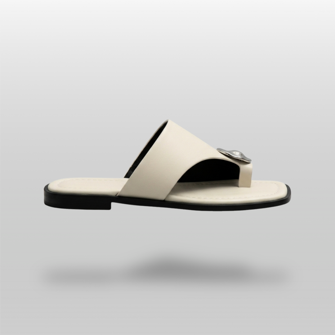 Cleo Sandal in Ivoire Argenté. Lateral profile showing the single ivory band, molten silver medallion and flat sole.