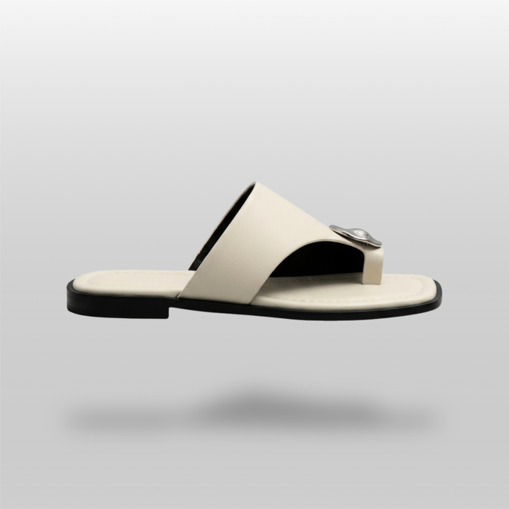 Cleo Sandal in Ivoire Argenté. Lateral profile showing the single ivory band, molten silver medallion and flat sole.
