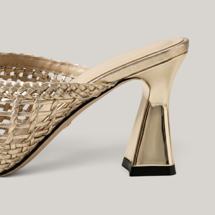 Dorée Mule in Or Tissé. Architectural 7.5cm trapezoidal block heel in metallic gold with black rubber base.