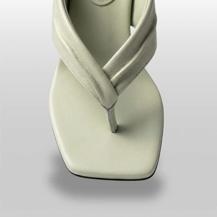 Close-up of twisted leather strap on sage green sandal