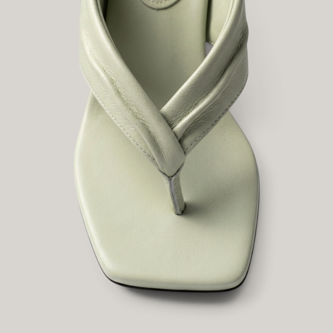Close-up of twisted leather strap on sage green sandal