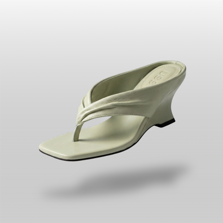 Sculptural wedge sandal in sage green leather, twisted strap detail