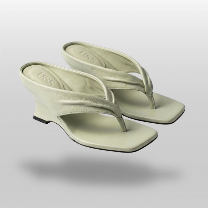 Pair of sage green sculptural wedge sandals, symmetrical view