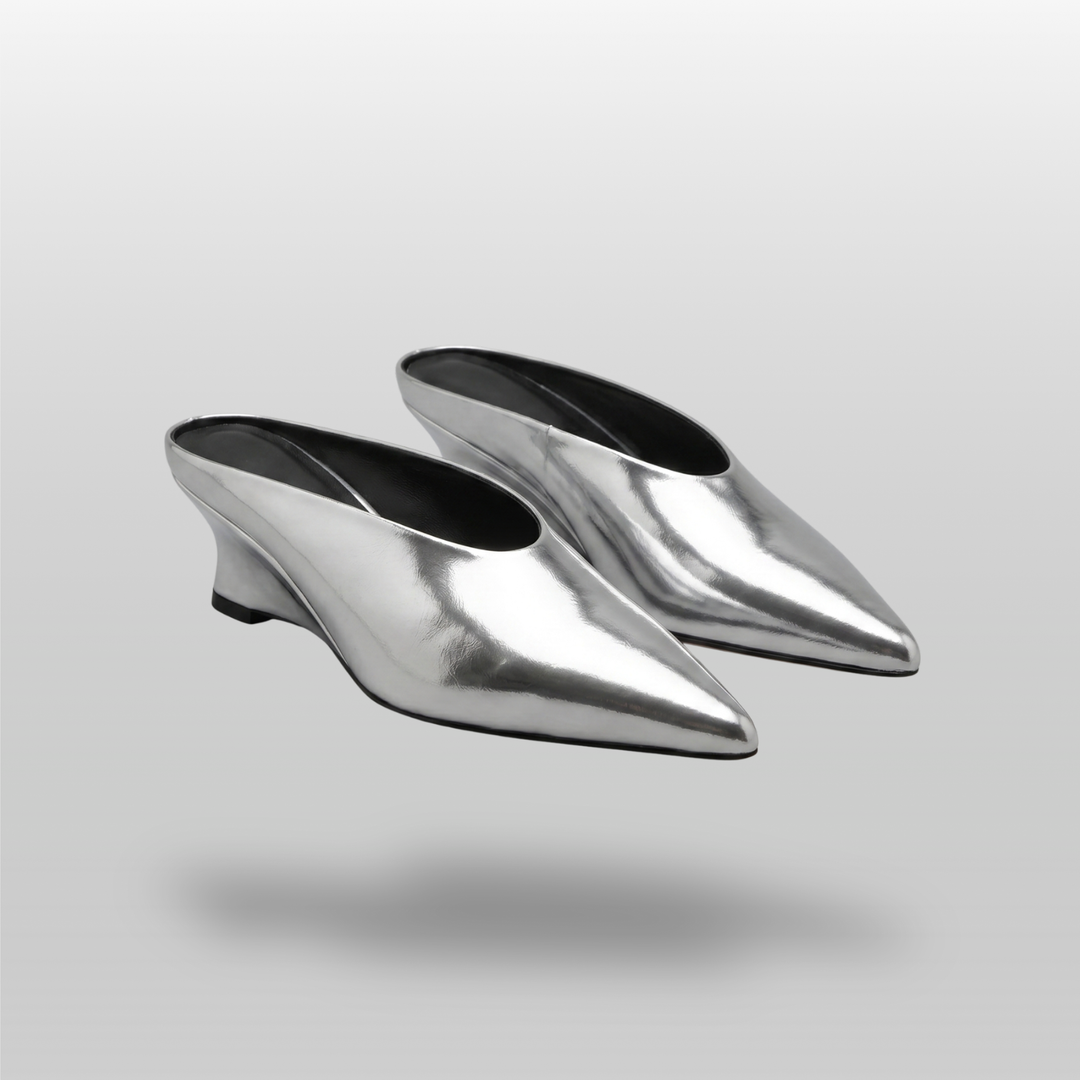 Pair of slip-on Lumière Mules in a highly reflective mirrored silver Argent Vif finish.