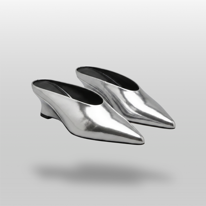 Pair of slip-on Lumière Mules in a highly reflective mirrored silver Argent Vif finish.