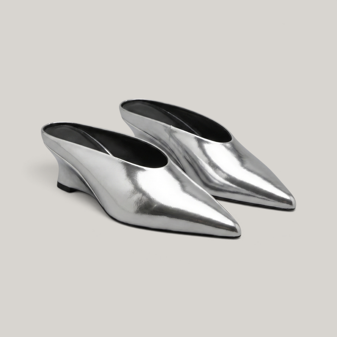 Pair of slip-on Lumière Mules in a highly reflective mirrored silver Argent Vif finish.