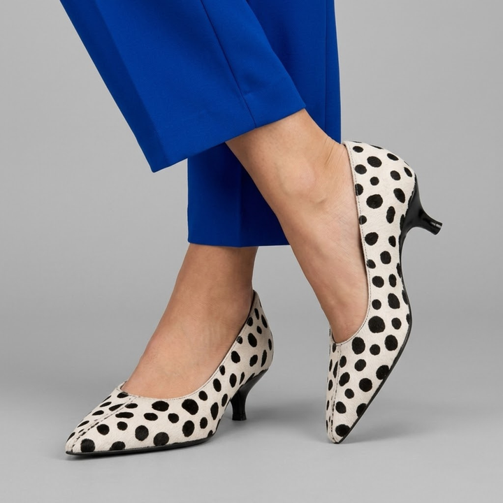 Spotted ivory pumps styled with cobalt blue tailored trousers