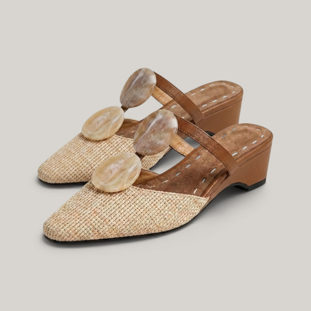 Paloma Mule in Sable Doré. Pair of raffia and camel leather mules with marbled resin medallion detail and low wedge heel.