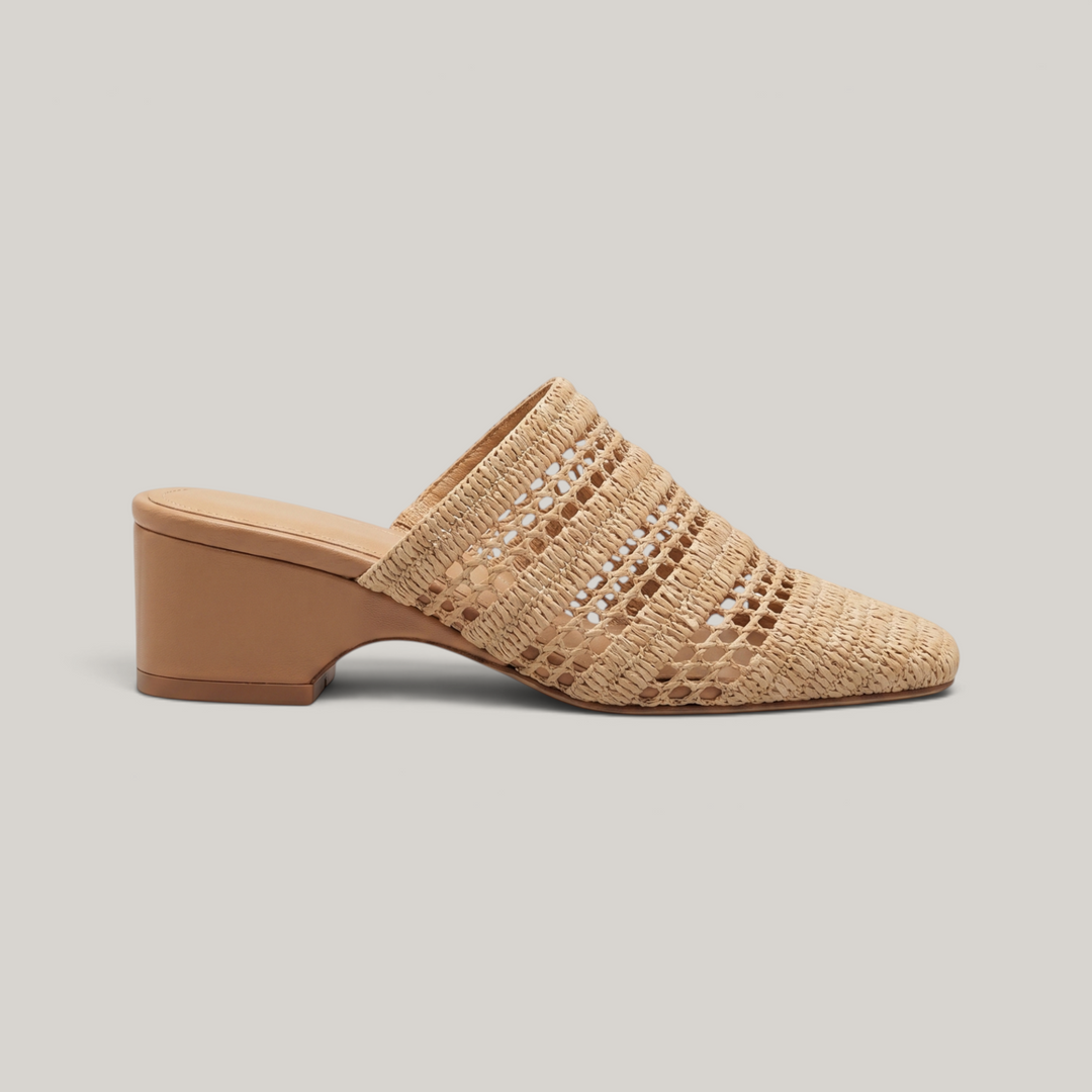 Side view of the Riviera Mule in Sable Naturel, featuring an open raffia weave, square toe silhouette, and a 6cm block heel.