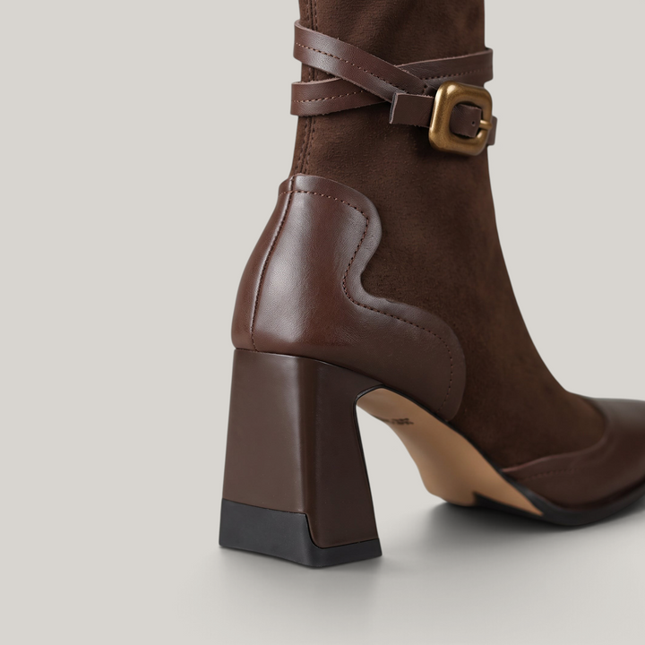 Flared block heel and wave-edge cowhide heel counter of the Romy Bootie in Brun Noisette