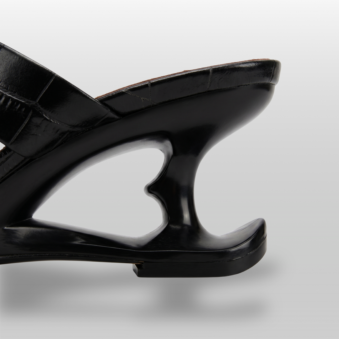 Sculpture Sandal in Noir Croco. Detail of the architectural 6cm negative-space cut-out heel.