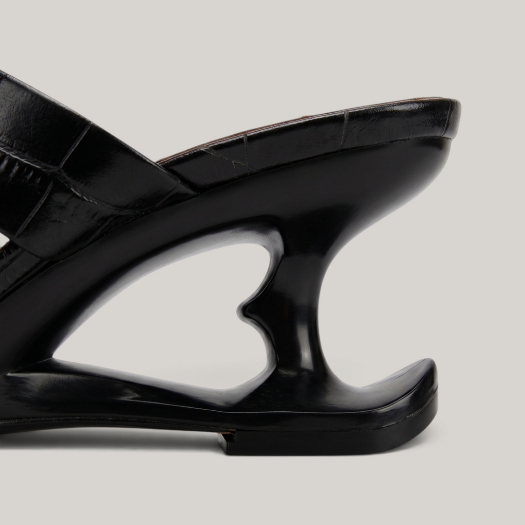 Sculpture Sandal in Noir Croco. Detail of the architectural 6cm negative-space cut-out heel.