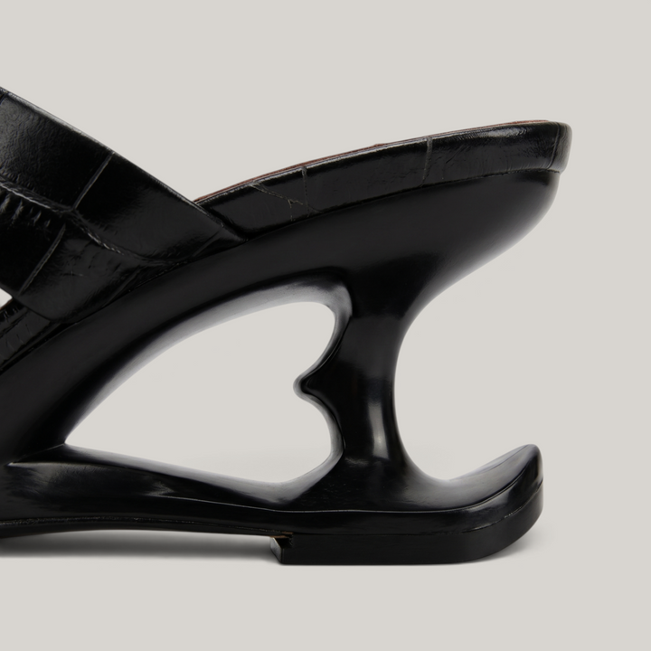 Sculpture Sandal in Noir Croco. Detail of the architectural 6cm negative-space cut-out heel.