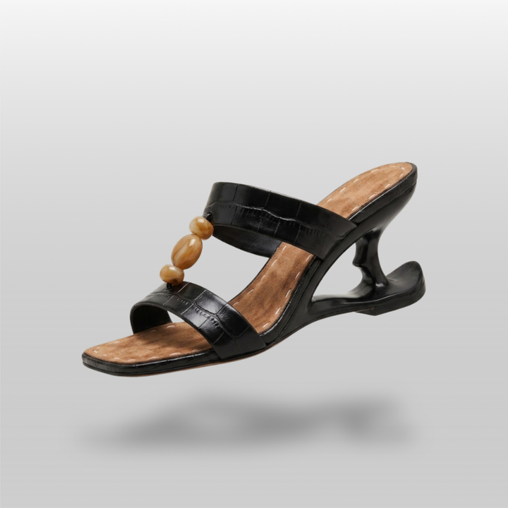 Sculpture Sandal in Noir Croco. Crocodile-embossed leather sandal with a sculptural cut-out heel and amber resin beads.