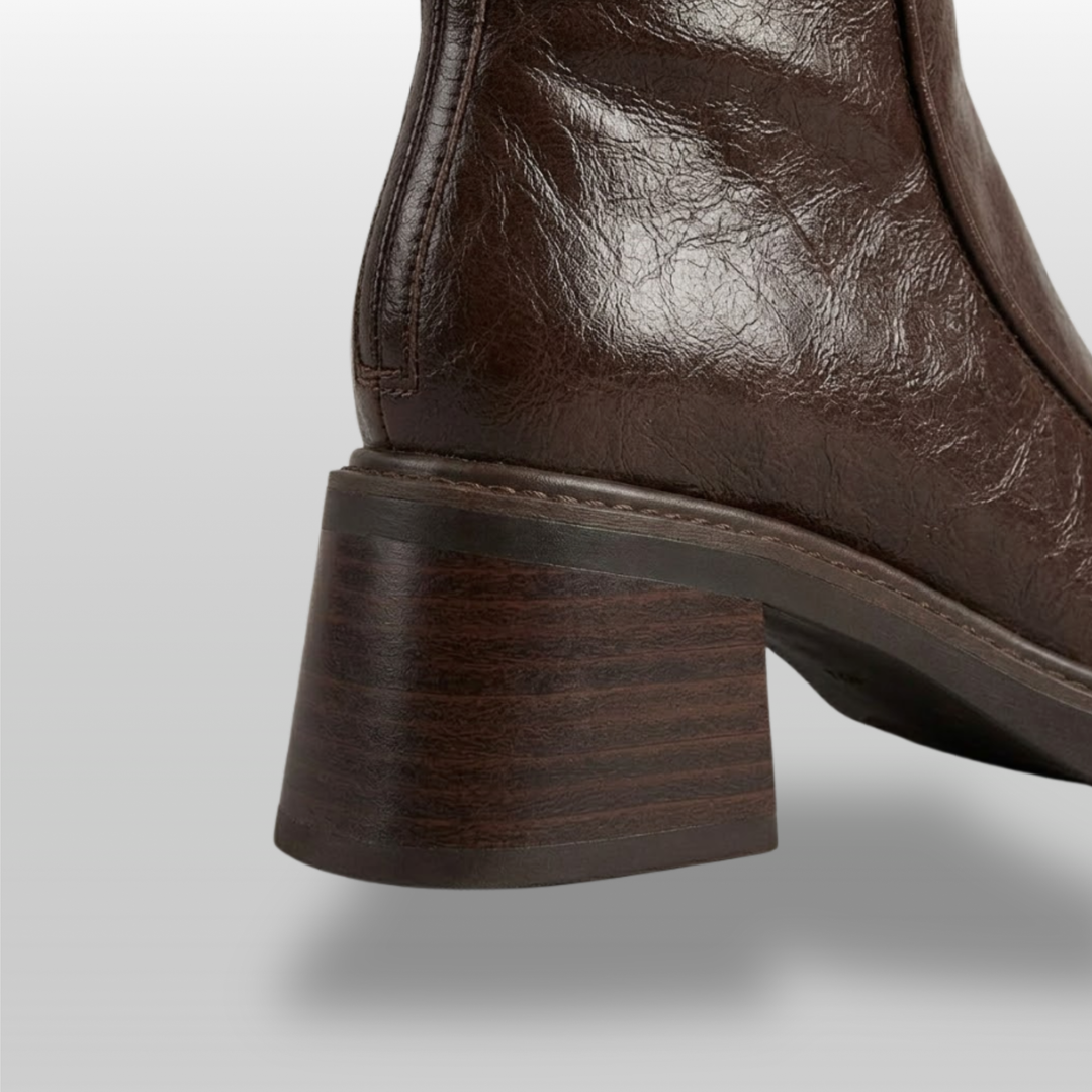 Close-up of stacked wood-grain block heel on brown knee-high boot