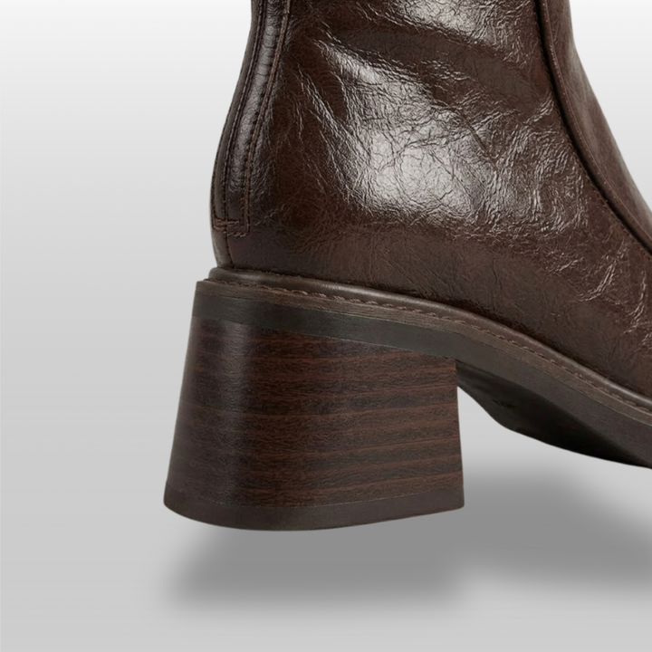 Close-up of stacked wood-grain block heel on brown knee-high boot