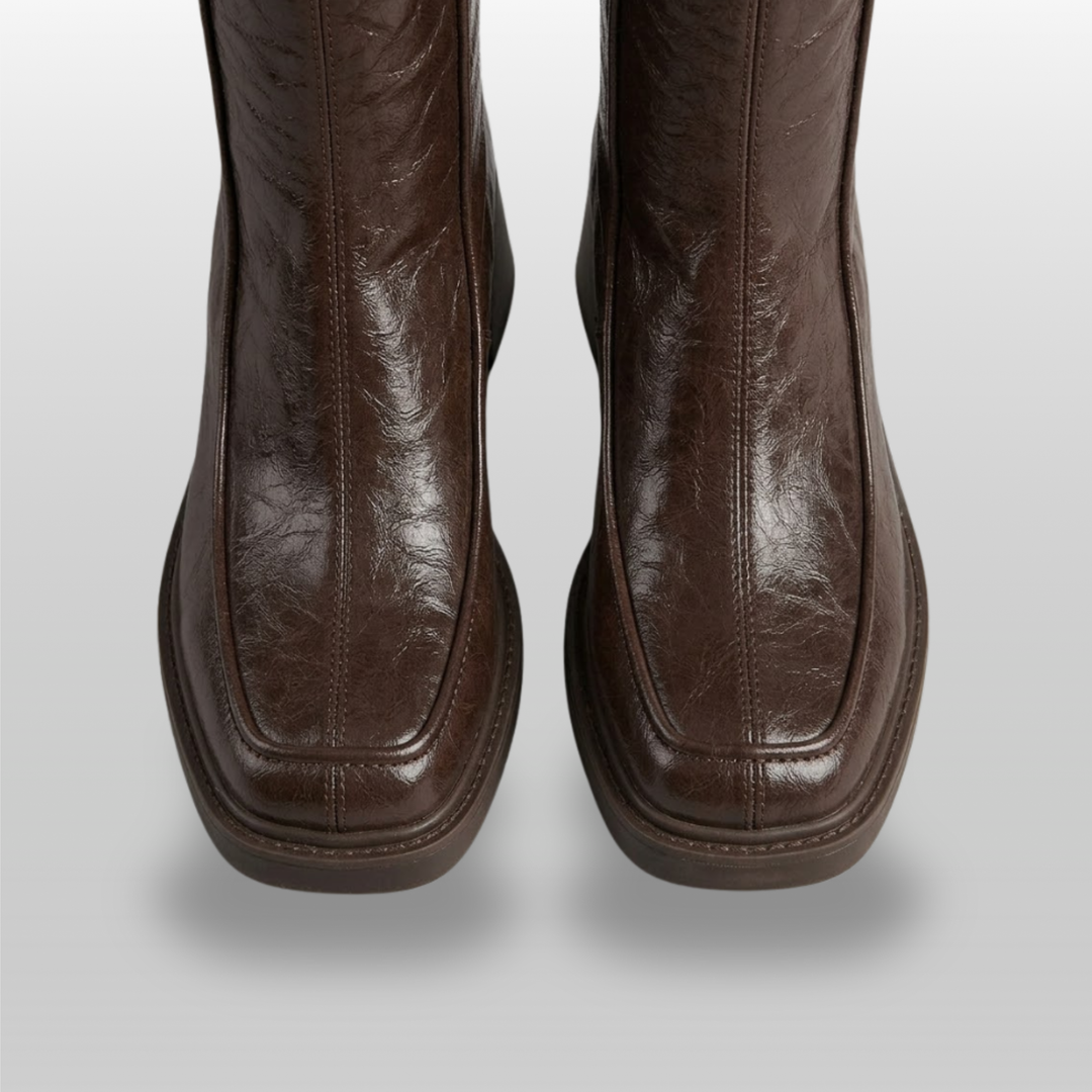 Close-up of moc-toe seam and squared toe on brown knee-high boots