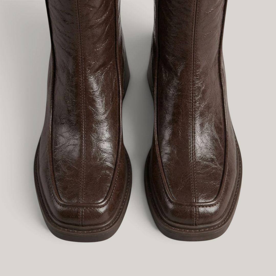 Close-up of moc-toe seam and squared toe on brown knee-high boots
