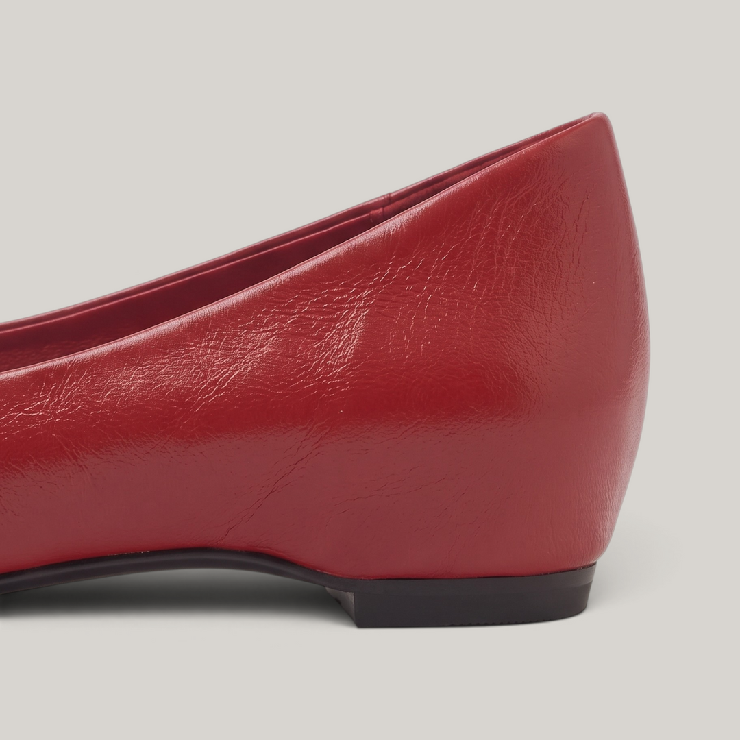 Close-up of red flat heel showing concealed lift and thin sole edge