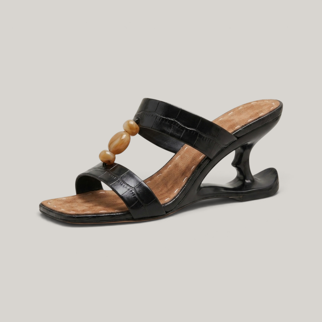 USS® Shoes Sculpture Sandal in noir crocodile-embossed leather with amber resin beads and architectural wedge heel.