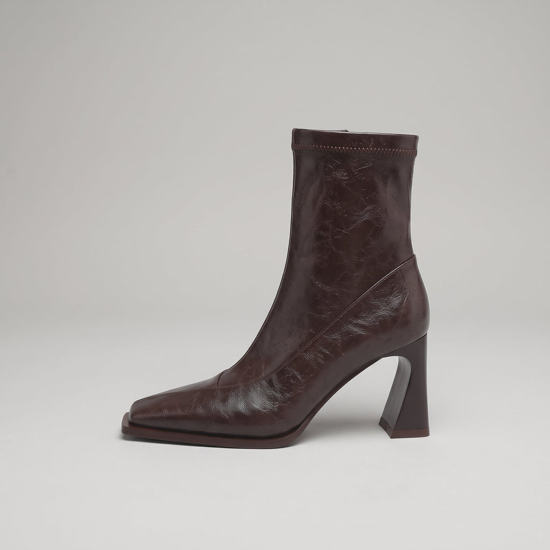 Side view of the Vienne Bootie in Moka Ciré, showing the flared heel and diagonal seam panel