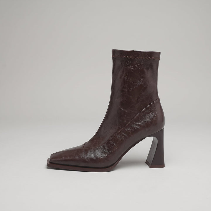 Side view of the Vienne Bootie in Moka Ciré, showing the flared heel and diagonal seam panel