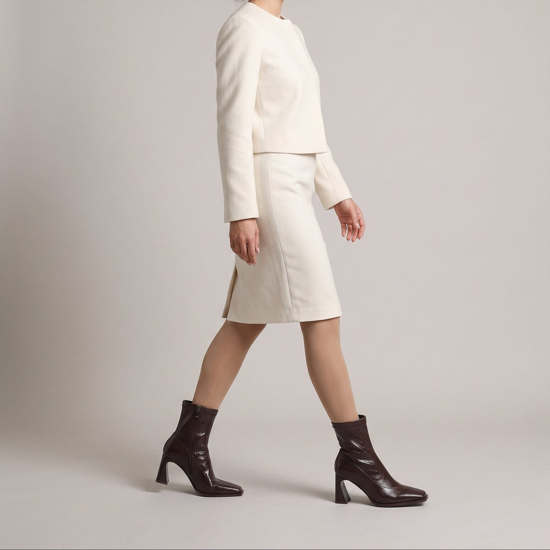 Vienne Bootie in Moka Ciré worn with an ecru collarless jacket and wool pencil skirt