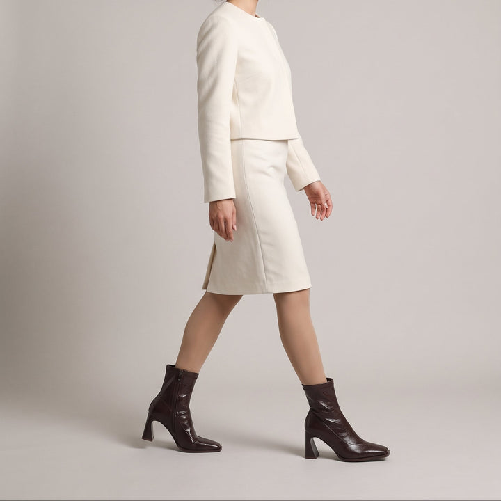Vienne Bootie in Moka Ciré worn with an ecru collarless jacket and wool pencil skirt